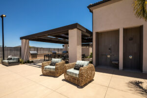 outdoor dining area at Delhaven Pointe with grills, lounge chairs and an outdoor shower