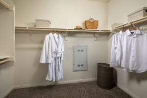 spacious closet with robes and collared shirts hanging