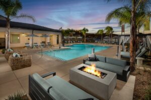 swimming pool at sunset with lounge furniture and a firepit