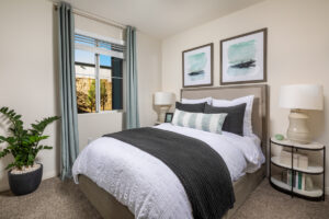 bright bedroom with white bedding and large windows